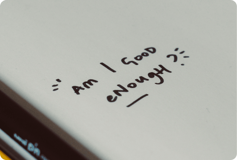 Words "am I good enough" on paper
