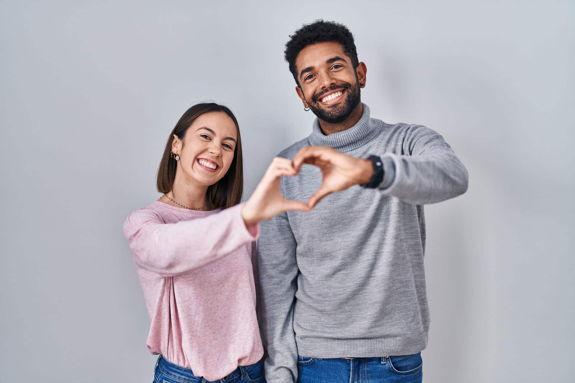 Couple forming a heart with their hands together.