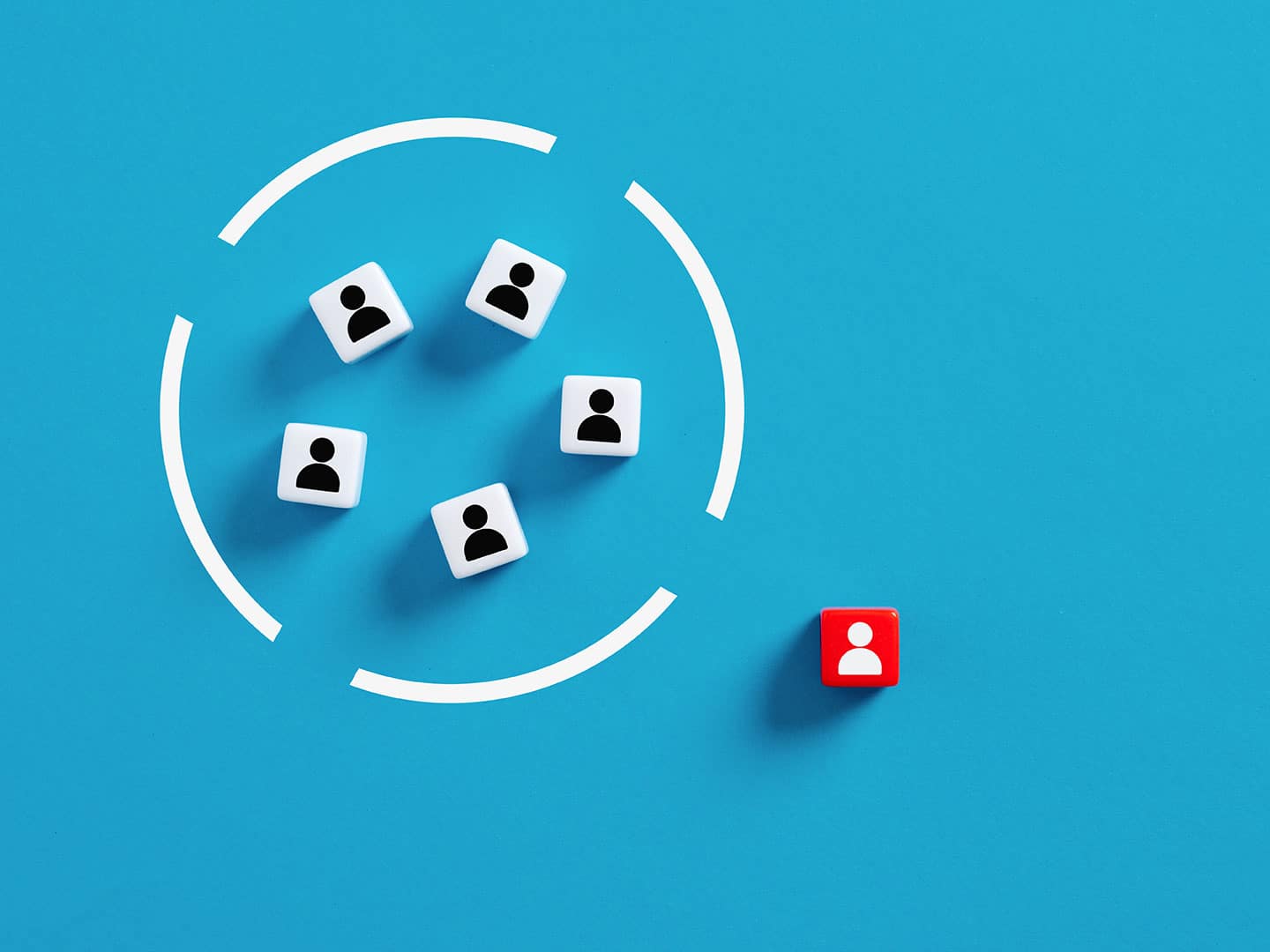 Multiples white blocks imprinted with people's profile inside a circle and one red block with a person's silhouette outside of the circle.